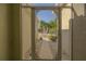 View through screened front door to landscaped walkway with palm trees and manicured bushes at 1038 Emerald Dunes Dr, Sun City Center, FL 33573