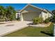 Lovely home with a well-manicured lawn, palm trees, and a patterned driveway, enhancing curb appeal at 1038 Emerald Dunes Dr, Sun City Center, FL 33573