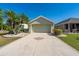 Lovely home with a well-manicured lawn, palm trees, and a patterned driveway, enhancing curb appeal at 1038 Emerald Dunes Dr, Sun City Center, FL 33573