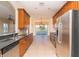 Long gourmet kitchen with a view of the pool and stainless steel appliances at 1038 Emerald Dunes Dr, Sun City Center, FL 33573