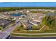 Aerial view of a neighborhood featuring a lake, modern homes, and lush greenery at 1044 Manzanar Pl, Wesley Chapel, FL 33543