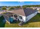 Aerial view of a home with a screened-in pool, patio, and a well-manicured lawn at 1044 Manzanar Pl, Wesley Chapel, FL 33543