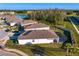 Aerial view of a home with a white exterior, screened-in pool, and a well-manicured lawn at 1044 Manzanar Pl, Wesley Chapel, FL 33543