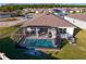 Aerial view of a home showcasing screened-in pool, patio, and landscaped backyard in a neighborhood at 1044 Manzanar Pl, Wesley Chapel, FL 33543