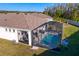 Aerial view of the home showcasing the backyard with a screened in pool and the surrounding landscaping at 1044 Manzanar Pl, Wesley Chapel, FL 33543