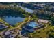 Stunning aerial view of community pool and clubhouse with lake and lush landscaping at 1044 Manzanar Pl, Wesley Chapel, FL 33543