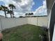 Spacious backyard with well-maintained lawn, white vinyl fence, and a gate at 1044 Manzanar Pl, Wesley Chapel, FL 33543