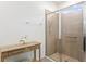 Bathroom showcasing walk-in glass shower, decorative console table, and neutral tile at 1044 Manzanar Pl, Wesley Chapel, FL 33543