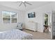 Light bedroom featuring a bed, dresser, and comfy armchair, all bathed in natural light from a large window at 1044 Manzanar Pl, Wesley Chapel, FL 33543