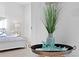 Cozy bedroom vignette featuring a table adorned with a teal vase and the word 