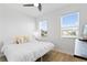 Bright bedroom featuring large windows with blinds, a ceiling fan, and wood floors at 1044 Manzanar Pl, Wesley Chapel, FL 33543