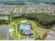 High aerial view of the community, highlighting pool, clubhouse, and various amenities nestled amidst lush greenery at 1044 Manzanar Pl, Wesley Chapel, FL 33543