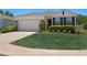Charming single-story home with a well-manicured lawn and attached two-car garage at 1044 Manzanar Pl, Wesley Chapel, FL 33543