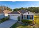 Charming single-story home features a well-manicured lawn, mature landscaping, and an attached two-car garage at 1044 Manzanar Pl, Wesley Chapel, FL 33543