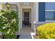Inviting front entrance featuring stone accents, decorative shrubs, and a welcoming wreath on the door at 1044 Manzanar Pl, Wesley Chapel, FL 33543