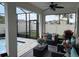 Covered patio with wicker furniture, colorful pillows and ceiling fan, offering a comfortable retreat at 1044 Manzanar Pl, Wesley Chapel, FL 33543