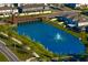 Beautiful aerial view of a pond with a fountain surrounded by houses in a lush, green community at 1044 Manzanar Pl, Wesley Chapel, FL 33543
