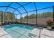Inviting screened-in pool area with a soothing fountain and picturesque landscaping at 1044 Manzanar Pl, Wesley Chapel, FL 33543