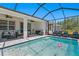 Beautiful screened-in pool area, complete with outdoor seating and views of the lush surroundings at 1044 Manzanar Pl, Wesley Chapel, FL 33543