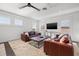 Spacious living room with bright windows, leather sofas, and a ceiling fan at 1110 Overlook Ct, Bradenton, FL 34208