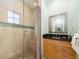 Bathroom features a tiled shower with glass door, dark granite countertop, and wood cabinets at 1140 81St S St, St Petersburg, FL 33707