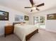 Cozy bedroom features a bed with a patterned cover, a ceiling fan, and sliding glass doors to the pool at 1140 81St S St, St Petersburg, FL 33707