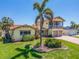Beautiful exterior view of a two-story home with a terracotta roof, lush landscaping, and a brick driveway at 1140 81St S St, St Petersburg, FL 33707