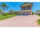 Charming two-story home with an attached two-car garage and brick driveway surrounded by mature landscaping at 1140 81St S St, St Petersburg, FL 33707