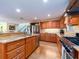 Spacious kitchen area with wood cabinets, granite countertops, stainless steel appliances, and a view of the living area at 1140 81St S St, St Petersburg, FL 33707