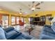 Inviting living room with tile floors, ceiling fans, large windows, comfortable seating, and an entertainment center at 1140 81St S St, St Petersburg, FL 33707