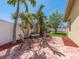 Cozy brick patio with a seating area surrounded by lush tropical landscaping, perfect for outdoor relaxation at 1140 81St S St, St Petersburg, FL 33707