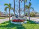 A sign for Yacht Club Estates is surrounded by Palm Trees and vibrant flowers at 1140 81St S St, St Petersburg, FL 33707