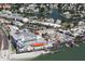 A coastal aerial view of buildings, a beach, and docked boats along the waterfront at 12924 Gulf Blvd # 310, Madeira Beach, FL 33708