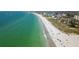 Scenic aerial view of a beach with turquoise water, white sand, and scattered buildings at 12924 Gulf Blvd # 310, Madeira Beach, FL 33708
