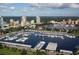 An aerial view of the marina with boat slips, downtown buildings and wooded area at 12924 Gulf Blvd # 310, Madeira Beach, FL 33708