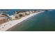 Wide aerial view of the beach shoreline and blue water with condos, buildings and a light city skyline in the distance at 12924 Gulf Blvd # 310, Madeira Beach, FL 33708