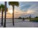 Scenic beach view featuring swaying palm trees, bike riders, and a colorful sunset sky at 12924 Gulf Blvd # 310, Madeira Beach, FL 33708