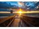 Picturesque view of beach access with wooden bridge and ocean sunset featuring clear blue water at 12924 Gulf Blvd # 310, Madeira Beach, FL 33708