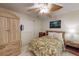 The bedroom features a ceiling fan, a charming tropical picture, and a wardrobe closet at 12924 Gulf Blvd # 310, Madeira Beach, FL 33708