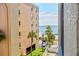 View of complex with manicured grounds and ocean view in the background, offering a tropical paradise at 12924 Gulf Blvd # 310, Madeira Beach, FL 33708
