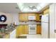 The kitchen features modern white appliances, ample cabinet storage, and granite countertops at 12924 Gulf Blvd # 310, Madeira Beach, FL 33708