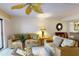 Cozy living room with floral sofas, glass coffee table, and decorative ceiling fan at 12924 Gulf Blvd # 310, Madeira Beach, FL 33708