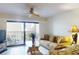 Living room with balcony access, ceiling fan and comfortable seating arrangements at 12924 Gulf Blvd # 310, Madeira Beach, FL 33708