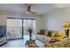 Living room with access to balcony, with ceiling fan and tile floors creates a comfortable space at 12924 Gulf Blvd # 310, Madeira Beach, FL 33708