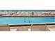 Relaxing pool area with clear blue water, lounge chairs, and a view of beach beyond the fence at 12924 Gulf Blvd # 310, Madeira Beach, FL 33708