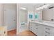 Well-lit bathroom features white cabinets, vanity, and shower-tub combo at 1318 Moreland Dr # 108, Clearwater, FL 33764