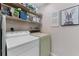 Efficient laundry room with washer, dryer, shelving, and ample storage space for cleaning supplies at 1318 Moreland Dr # 108, Clearwater, FL 33764