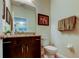 Charming powder room with granite countertop, dark wood cabinet, and framed art at 13217 Canopy Creek Dr, Tampa, FL 33625