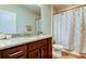 Bathroom features a granite countertop vanity, wood look flooring, and a shower with a patterned curtain at 13217 Canopy Creek Dr, Tampa, FL 33625