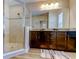 Bathroom with glass shower and double sinks with granite countertops and dark wood cabinets at 13217 Canopy Creek Dr, Tampa, FL 33625